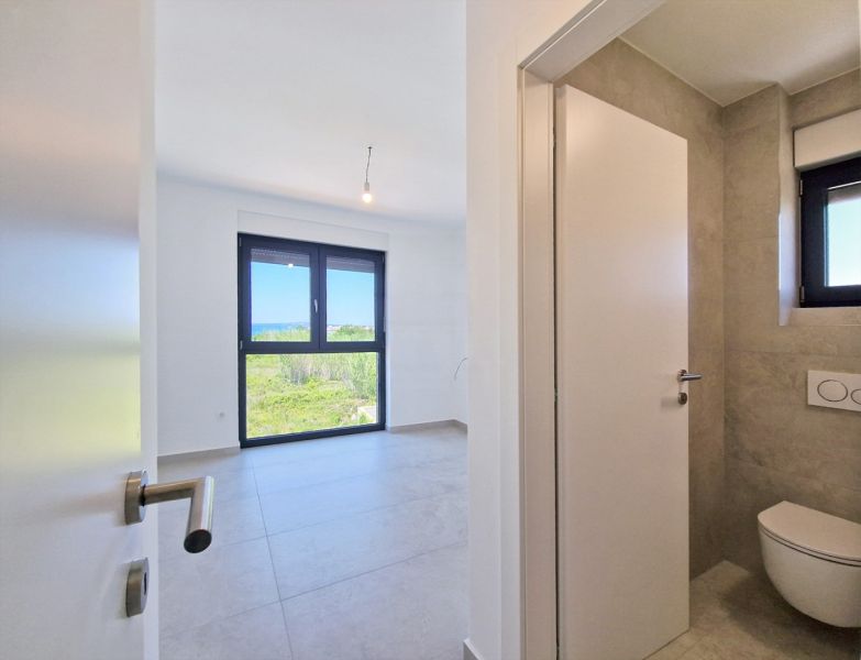 Interior of a 4-room apartment with light walls and tiles, modern windows and doors.