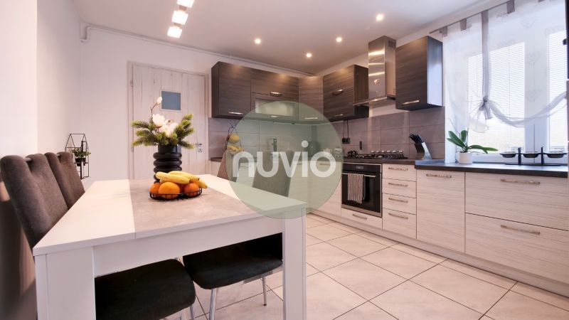 A kitchen in a family house with subtle decorations, fruit, and a white table.