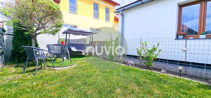 A garden with a seating area by a family house in Košťany nad Turcom with a lawn.