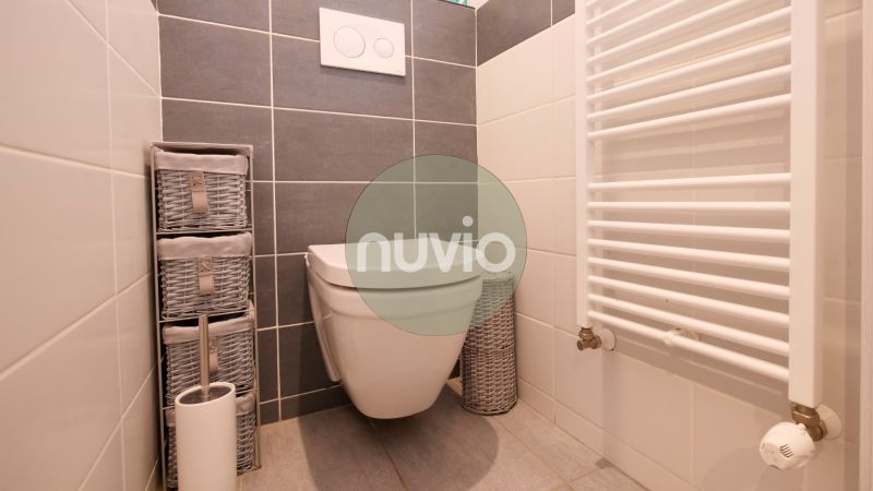 A bathroom with tiles and storage baskets in a family house.