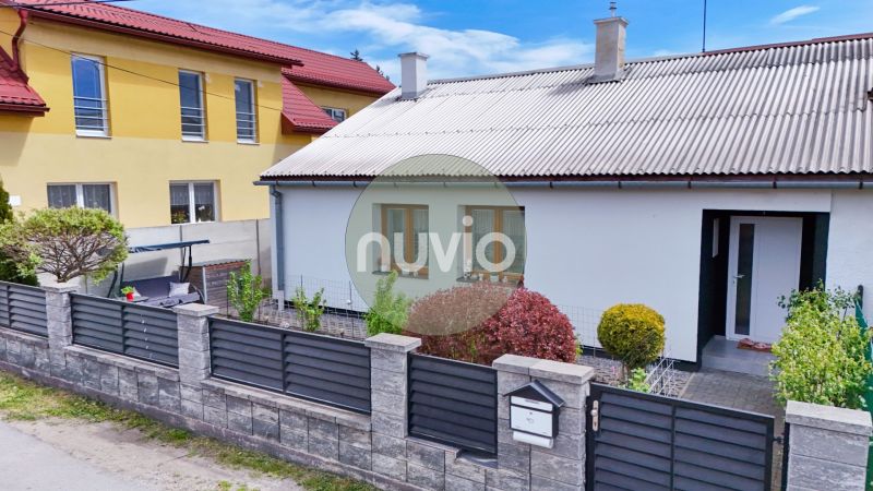A family house in Košťany nad Turcom with a landscaped garden and a modern fence.