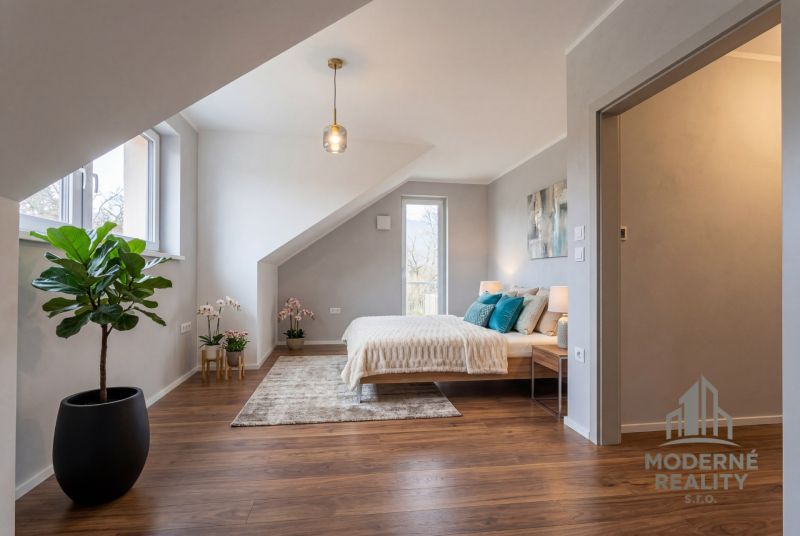 A bedroom in a family house with greenery and a wooden decor floor.