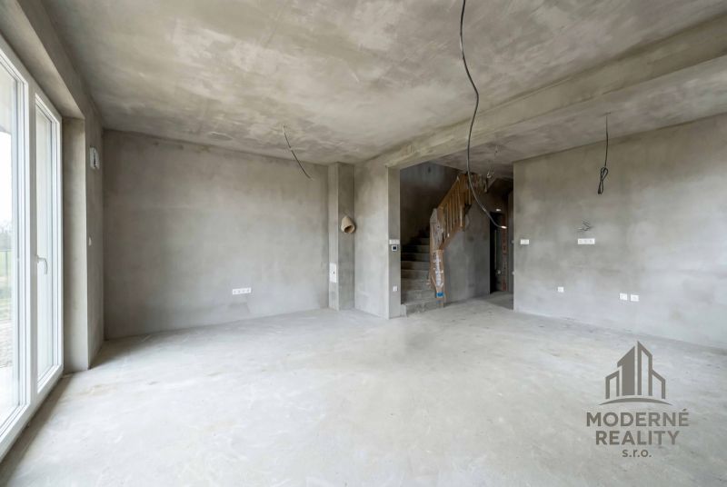 Unfinished interior of a family house with concrete walls and staircase.