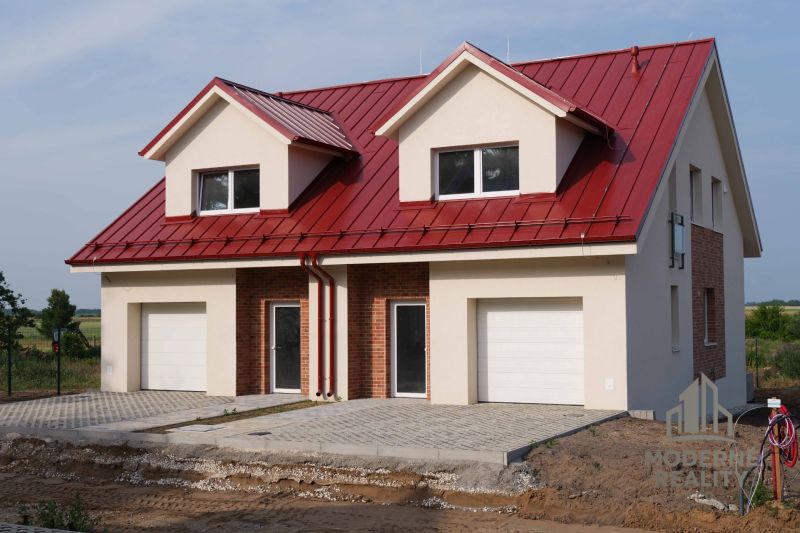 A family house in Andovce with a red roof and a double garage in a peaceful location.