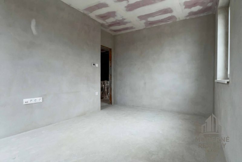 Unfinished room in a family house with a view of plastered walls and ceiling.