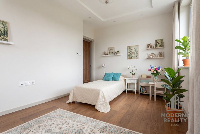 A room in a family house with a bed, decorations, and a wooden decor floor.