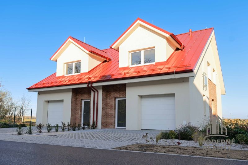 A family house in Andovce with a red roof and brick cladding.