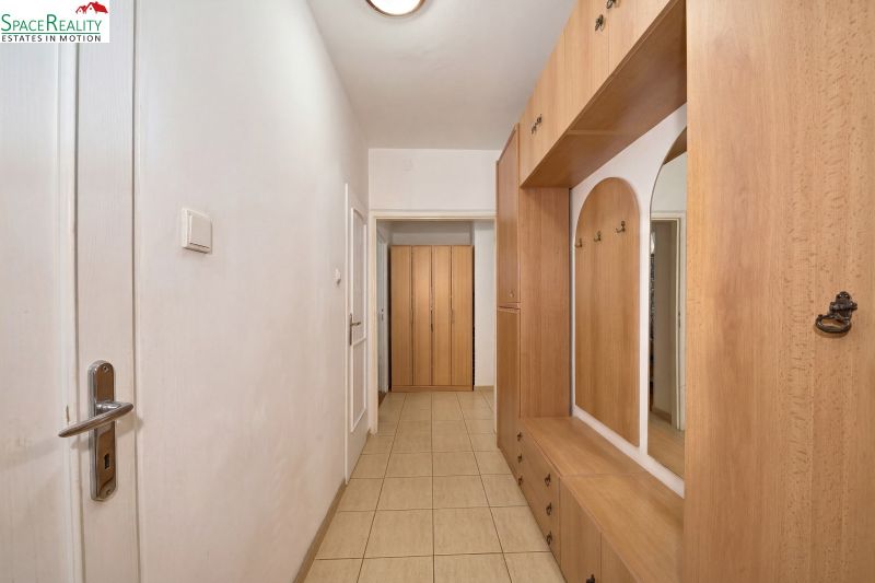 An entrance hall with a built-in wardrobe and tiled floor in a 2-room apartment.