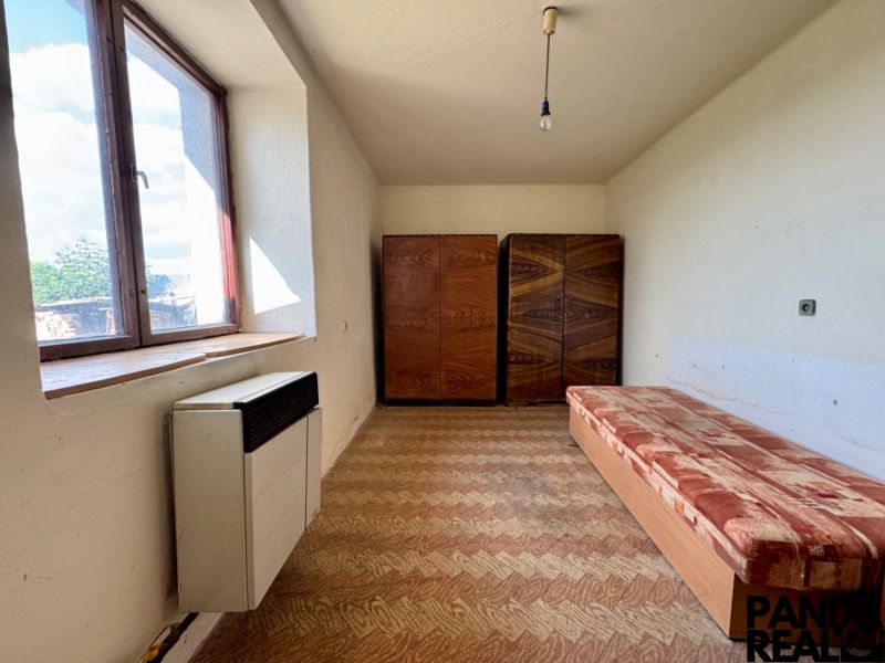 The interior of a family house with a sofa, a wardrobe, and a window.