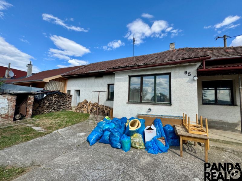 A family house in Horné Obdokovce with a supply of wood and waste in blue bags.