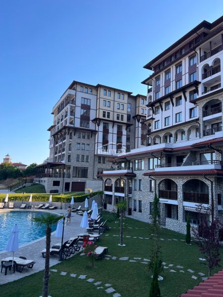 Exterior of a 2-bedroom apartment in the town of Sveti Vlas with a pool and sun loungers.