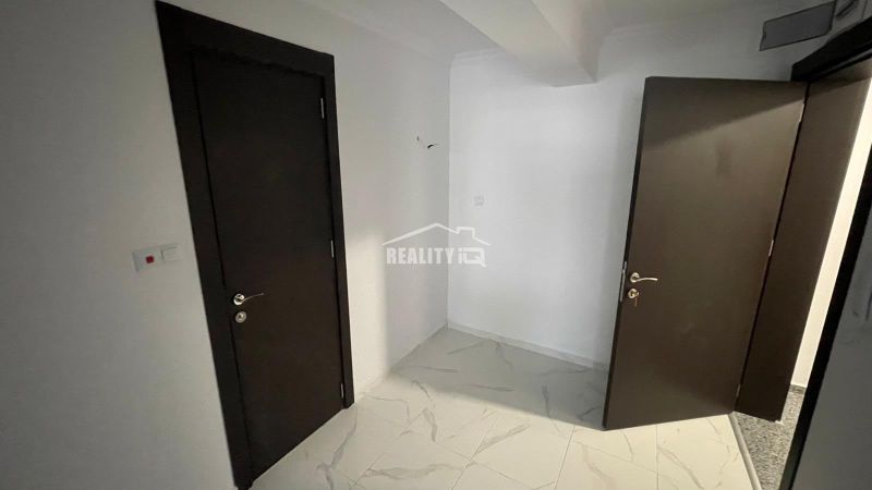 Interior of a 2-room apartment with white walls and doors in a dark shade.