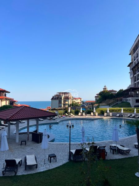 A view of the pool with surroundings and the sea in the town of Sveti Vlas, surrounded by sunbeds.