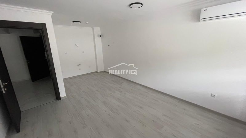 Interior of a 2-room apartment with white walls and a floor with a wooden decor.