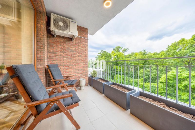 The balcony of a 3-room apartment on Ďumbierska Street in Bratislava III with comfortable seating and greenery.