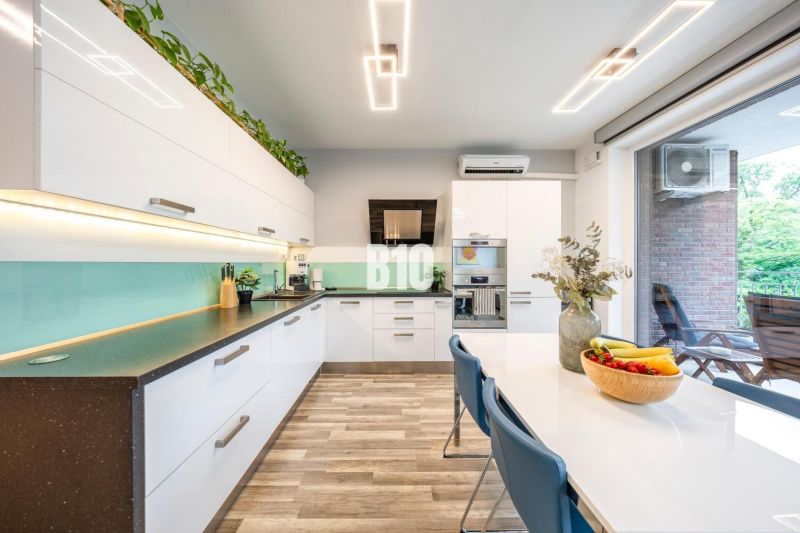 A kitchen with white cabinets and a wood-patterned floor in a 3-room apartment.