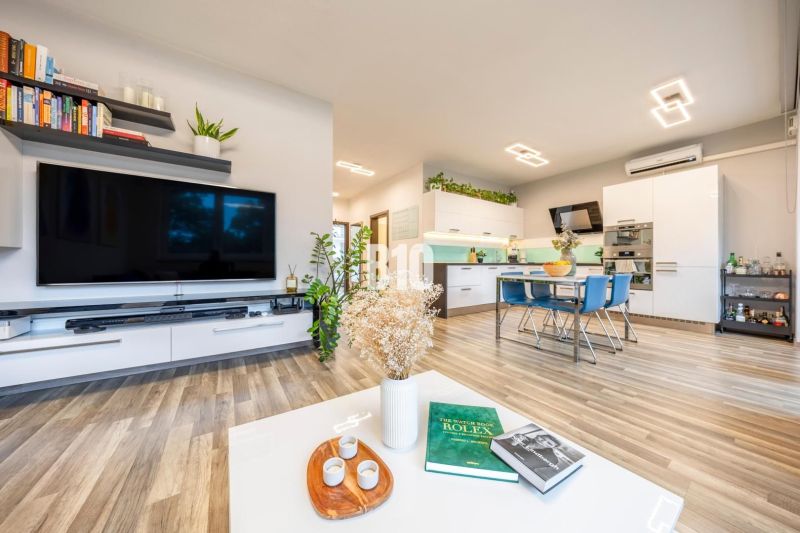 Living area with kitchen, wooden decor flooring, and modern furniture in a 3-room apartment.