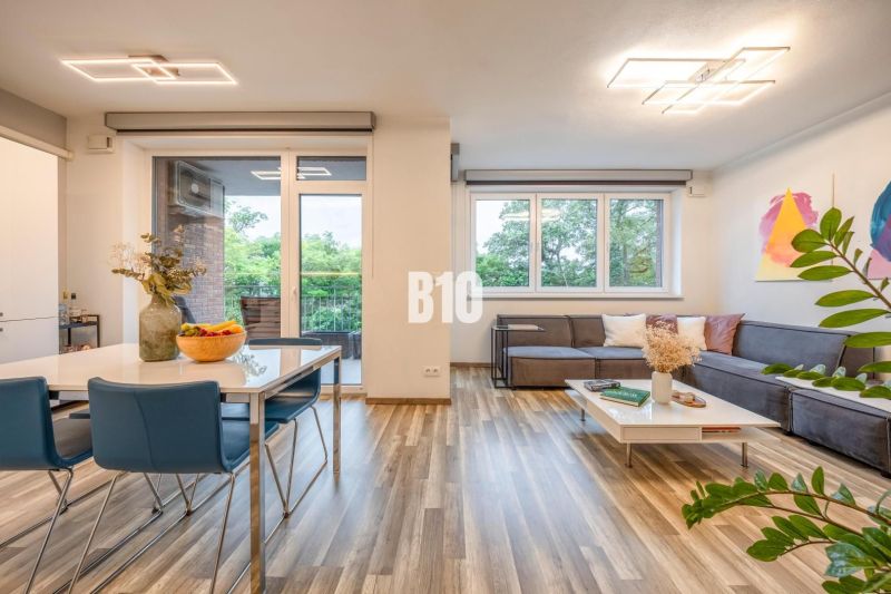 Living room with wood-patterned flooring, sofa, and dining table in a 3-room apartment.