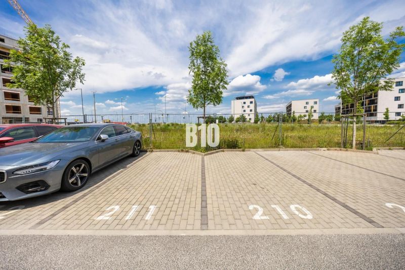 Parking lot with an available space and buildings in the background on Jána Langoša Street in Bratislava IV.