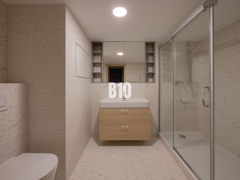 A bathroom with a bathtub, sink, and toilet in a 2-room apartment, neutral decor.