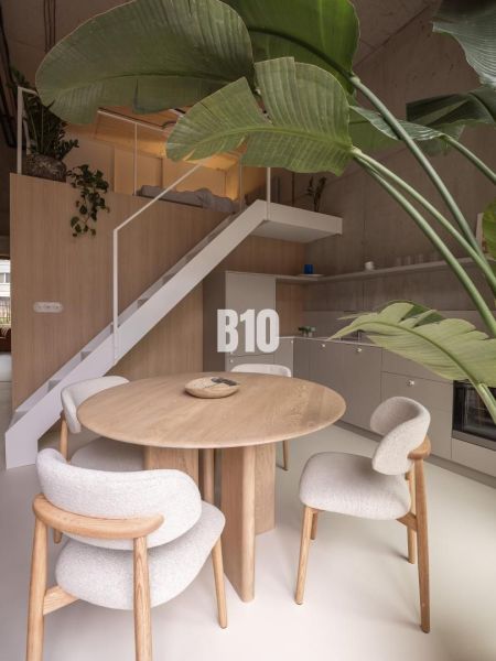 Interior of a 2-room apartment with a round table and wooden decor flooring.