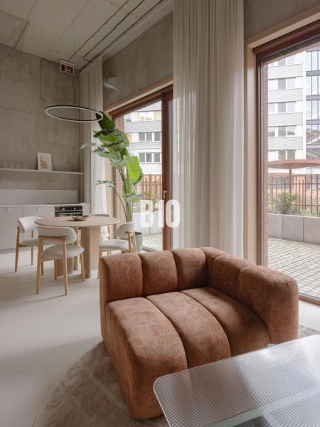 A bright living room with a comfortable sofa in a two-room apartment, with a dining table.
