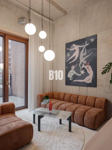Living room in a 2-room apartment with comfortable sofas and an artistic painting on the wall.