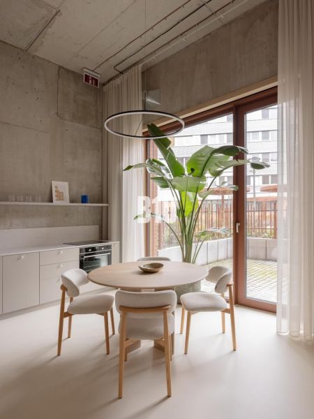 Dining area with a plant and glass doors in a 2-room apartment.
