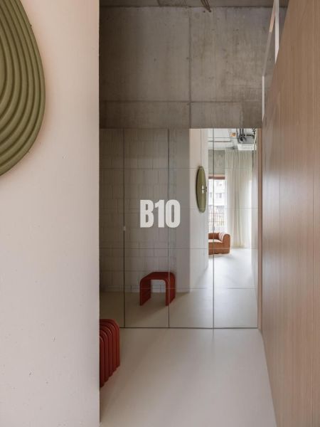 Mirrored doors in a 2-room apartment with a minimalist design and a concrete ceiling.