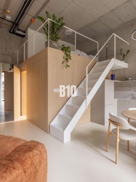 Interior of a 2-room apartment with a podium, stairs, and plants on a white background.