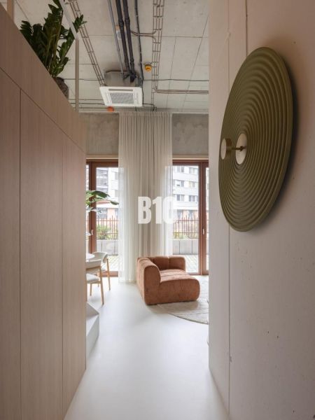 Interior of a 2-room apartment with a comfortable armchair, large windows, and modern decorations.