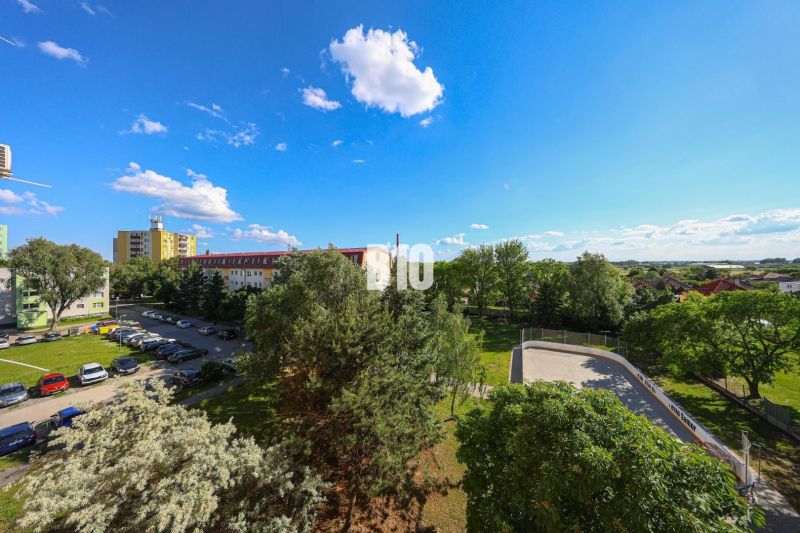 View of the parking lot and greenery from Dunajská Street in Šamorín near the 3-room apartment.