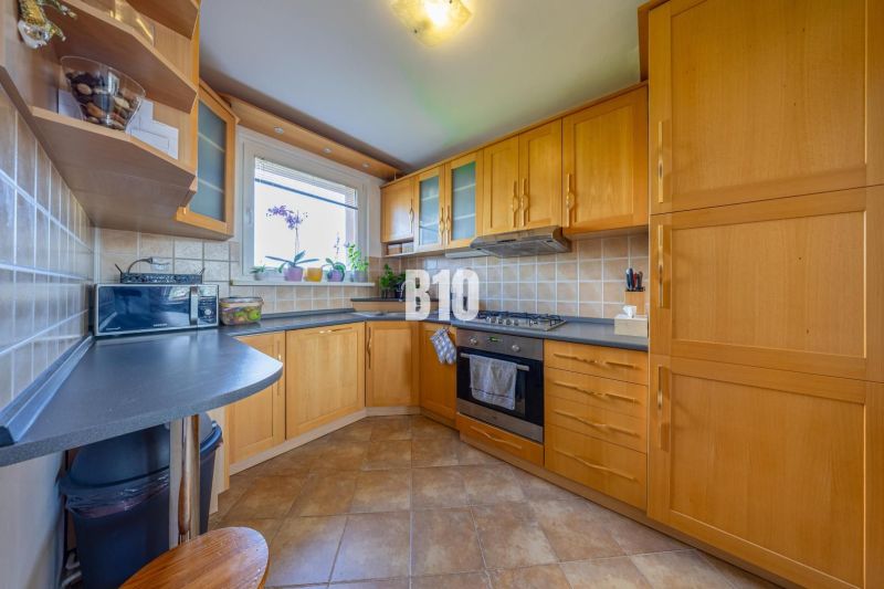 A kitchen in a 3-room apartment with a wooden decor and practical arrangement of appliances.