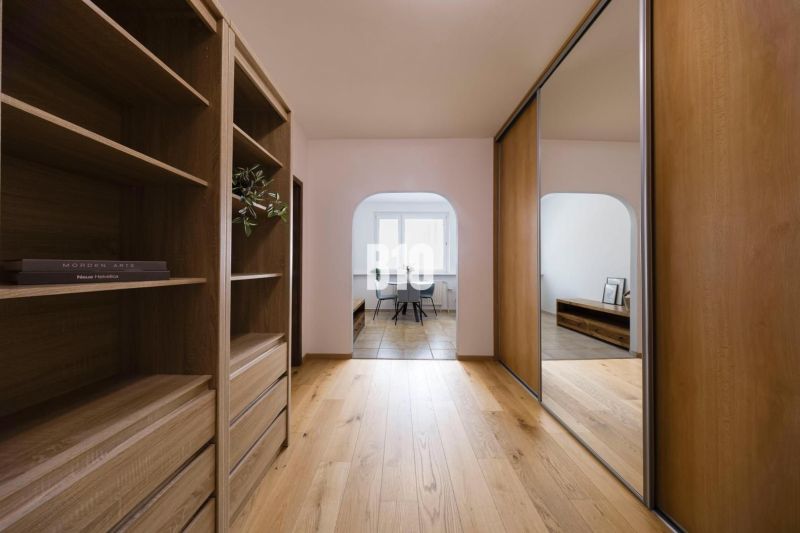 A hallway with built-in wardrobes and a floor with a wooden decor in a 3-room apartment.