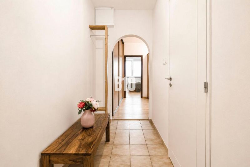 A narrow hallway with a flower vase in a 3-room apartment.