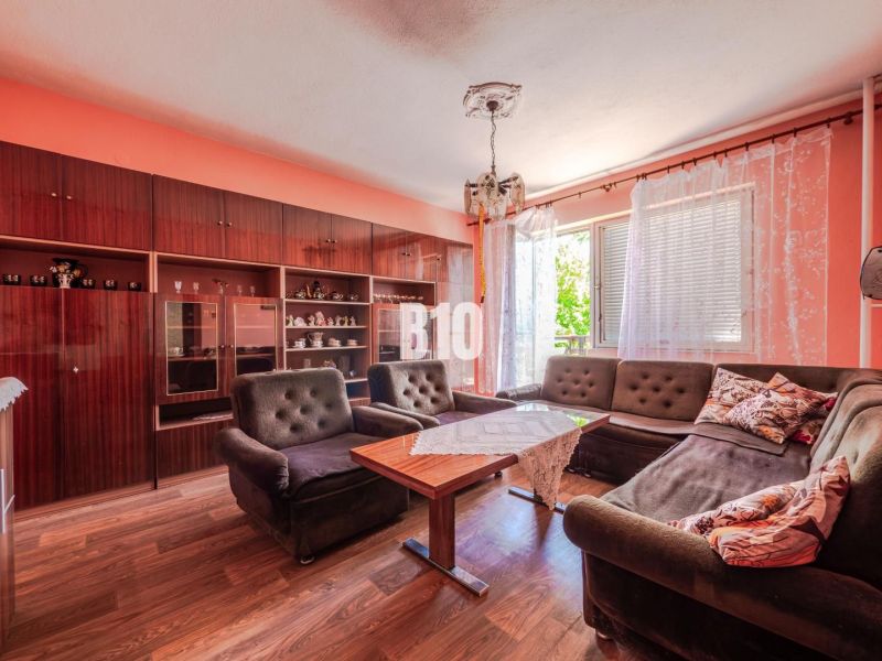 Living room in a family house with a sofa, furniture, and wooden decor flooring.
