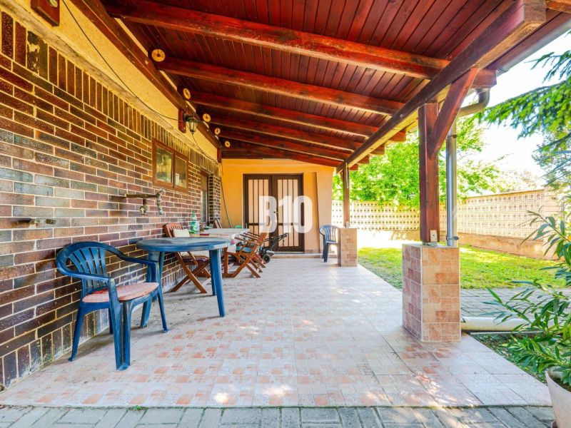 The terrace of a family house in Branč with plastic furniture and a wooden ceiling.