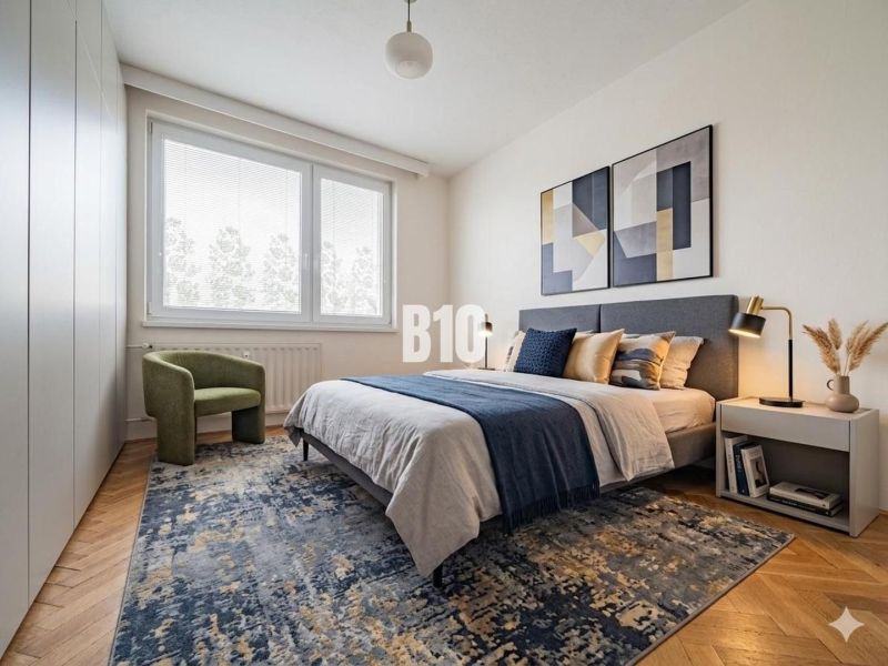 A bedroom in a three-room apartment with carpets, a bed, and a chair on a floor with a wooden decor.