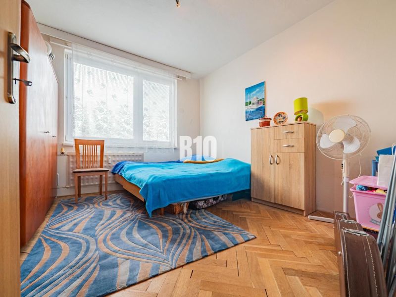 Bedroom in a 3-room apartment with a bed, furniture, and flooring with a wooden decor.