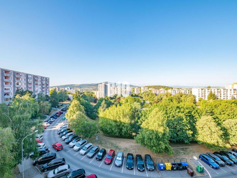 View of apartment buildings and greenery in Nitra, with a 3-room apartment in the background.