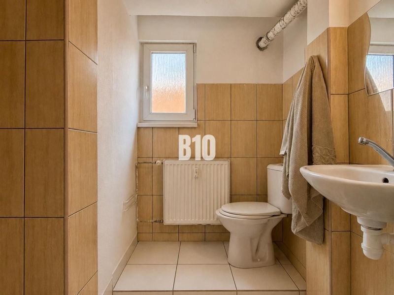 A bathroom in a two-room apartment with beige tiles.