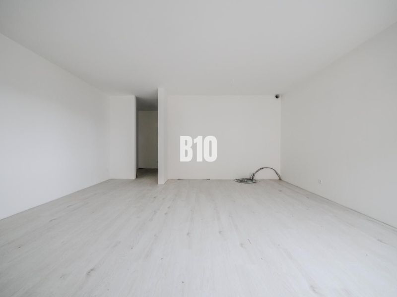 A bright room with a wooden decor floor in a studio apartment.