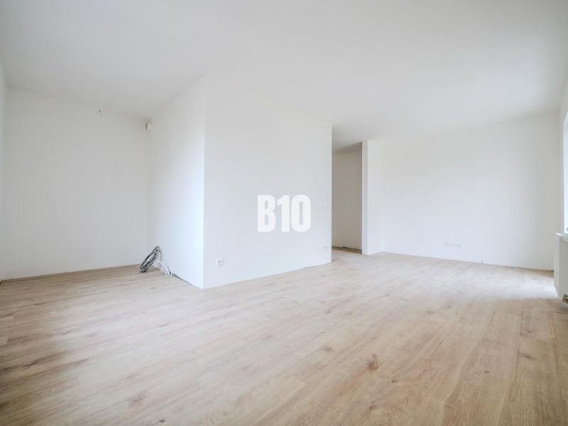 Bright room with wood-decor flooring in a studio apartment.