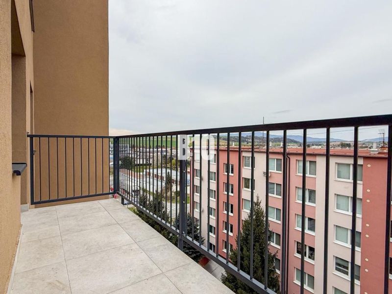The balcony of a 2-room apartment in Bánovce nad Bebravou with tiles and a view of the surroundings.