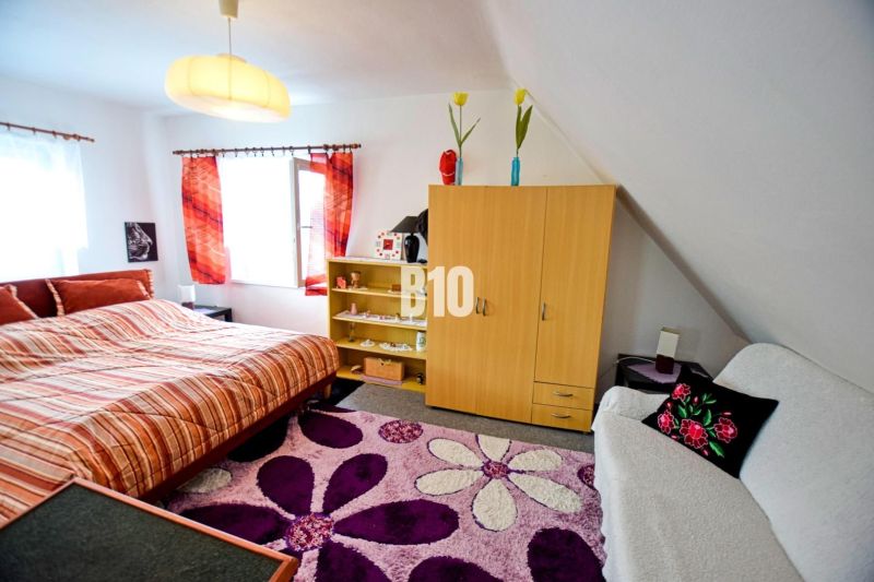 Interior of a cabin with a comfortable bed, colorful curtains, and a patterned carpet.