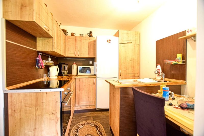 A kitchen in a cabin with wooden decor, equipped with appliances and storage space.