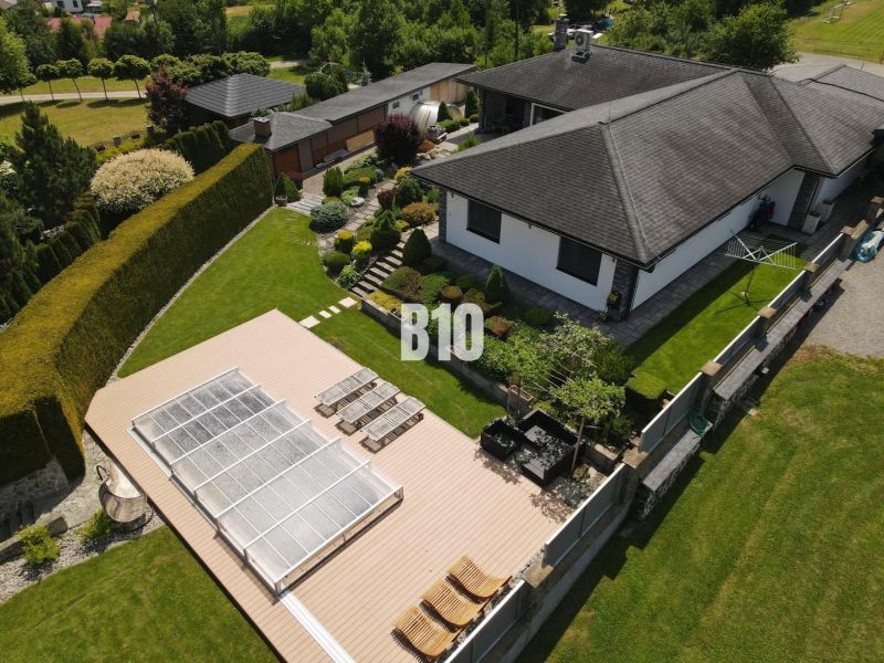 A family house in Súľov-Hradná with a terrace, swimming pool, and garden surrounded by greenery.
