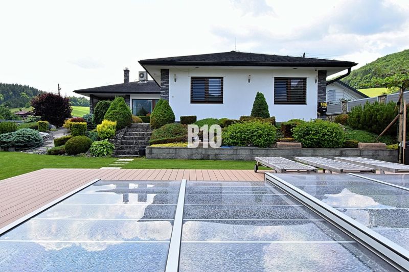 A family house in Súľov-Hradná with a swimming pool and a landscaped garden in a peaceful countryside.