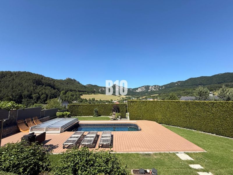 A swimming pool in the garden of a family house in Súľov-Hradná with a view of the surrounding mountains.