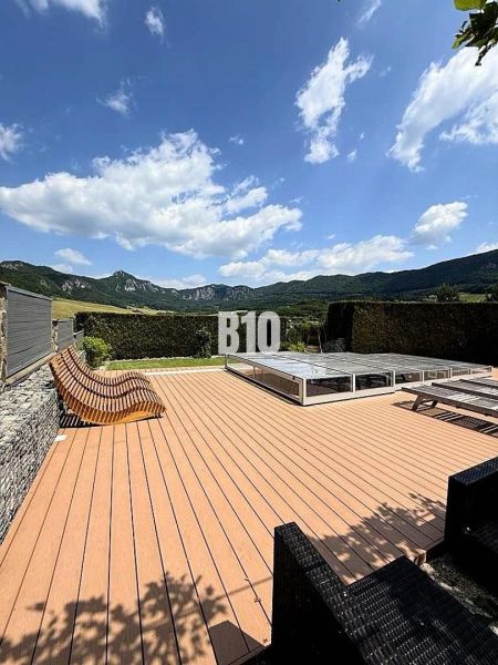 The terrace of a family house in Súľov-Hradná with a view of the mountains and a pool.